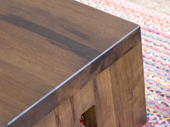 Coin supérieur d'une table en bois avec finition lisse et angle droit.
