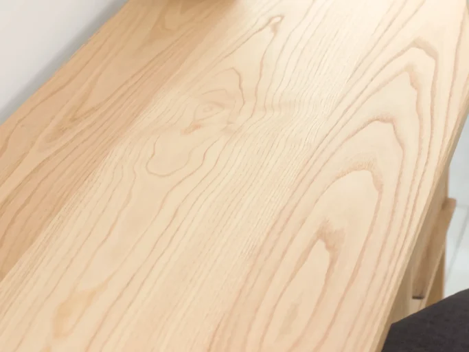 Surface en bois clair avec des motifs naturels et une finition lisse.