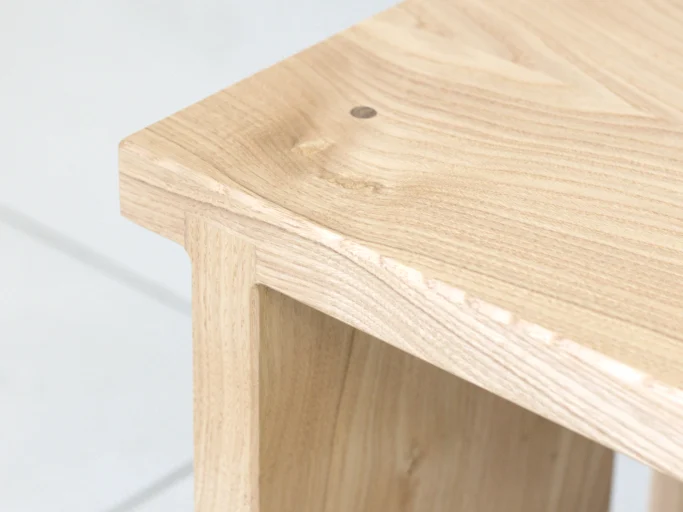 Coin d'une table en bois clair avec un design minimaliste.